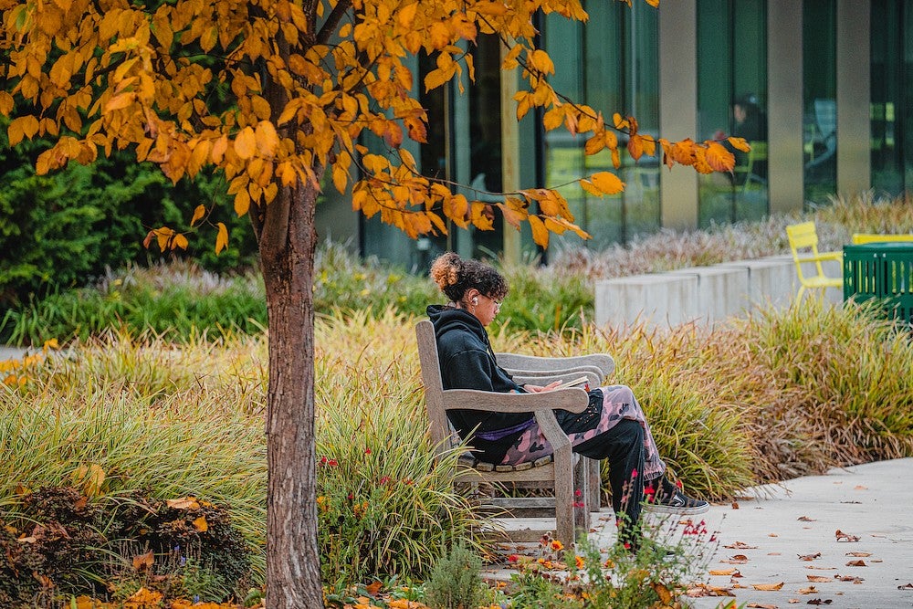 Student sitting on bench on campus