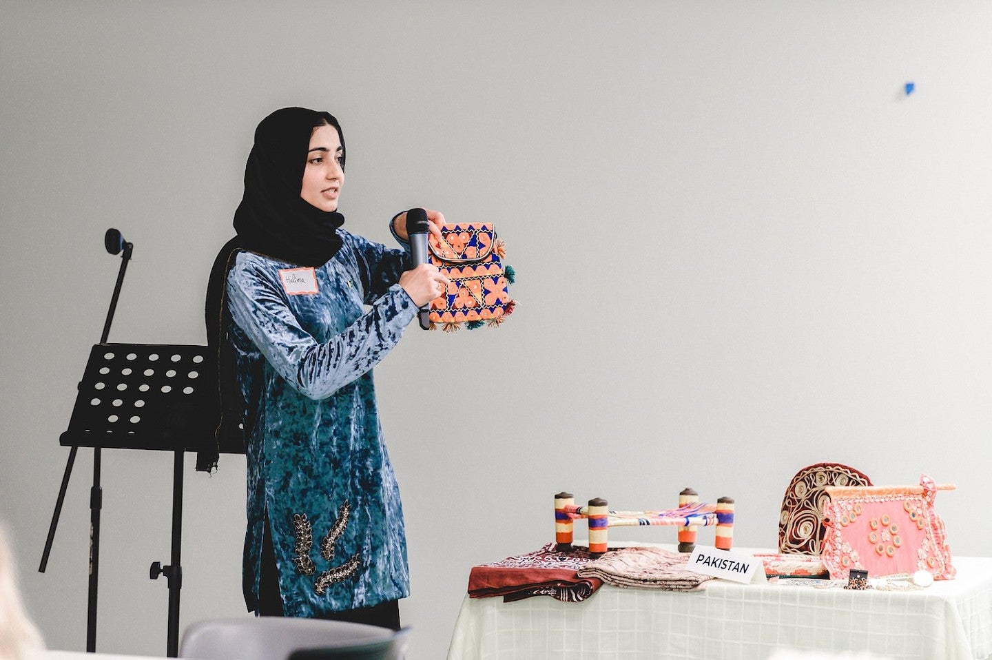 Pakistani student demonstrating cultural artifacts to a high school classroom