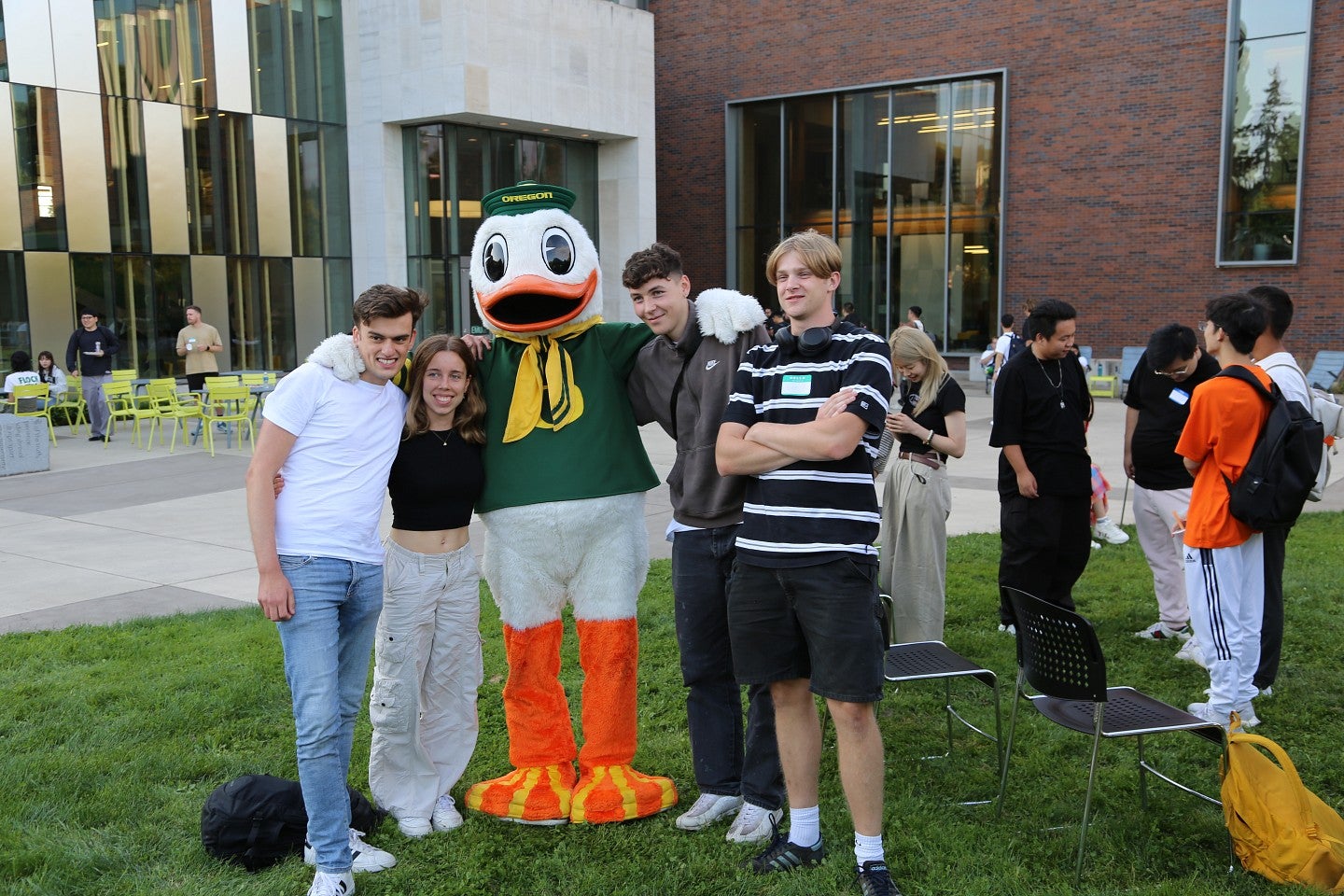 The Oregon Duck mascot with a group of international students on campus