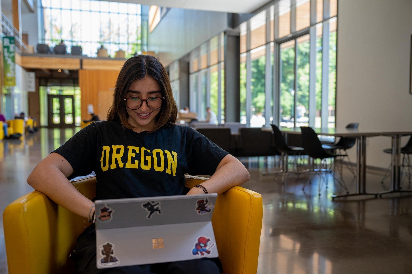 Women sitting in a yellow chair working on a computer