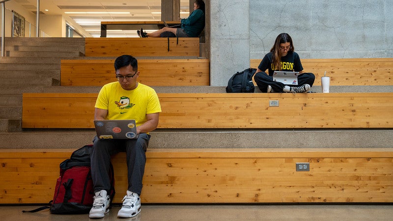 Two student sitting with their laptops