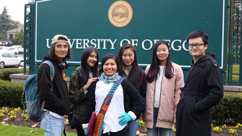 Students standing in front of the UO sign