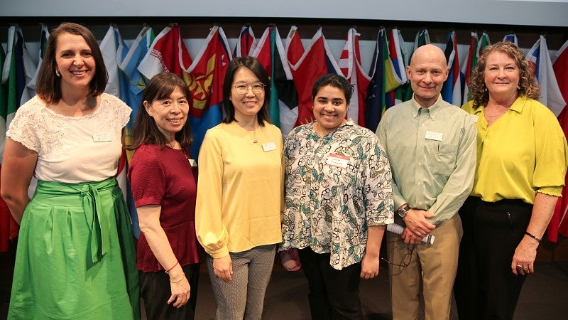 ISSS staff standing in front of country flags at International Student Orientation